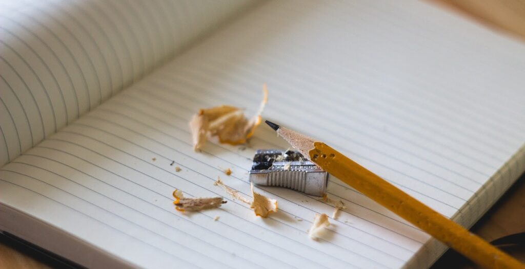 Teroitettu kynä on vihkon päällä.