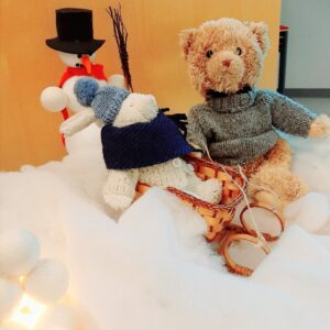 Pehmonalle, pehmopupu ja lumiukko talvisesti puettuina.